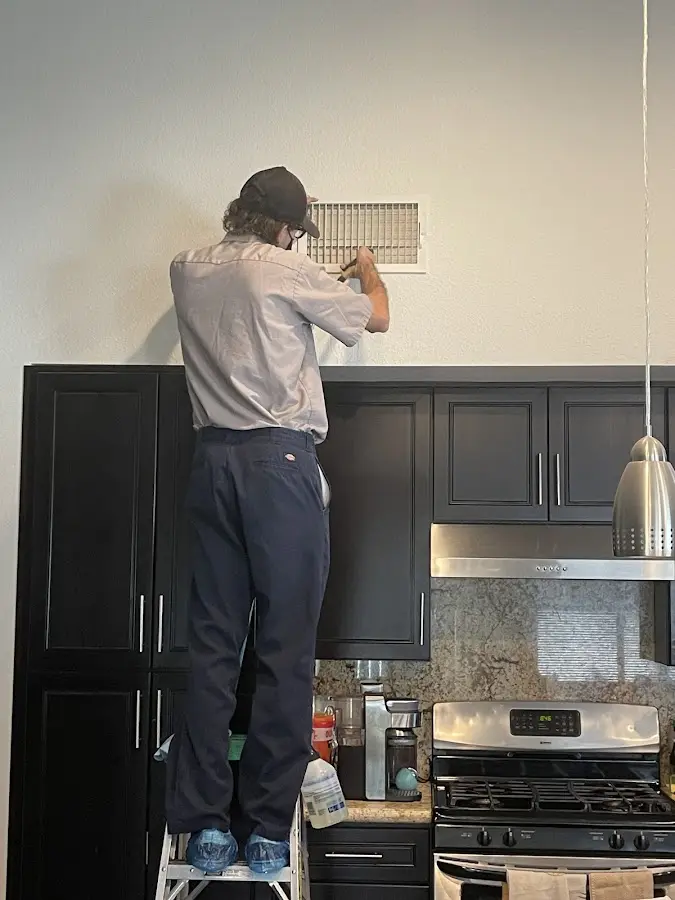 Technician inspecting an air vent during HVAC service in Hightstown